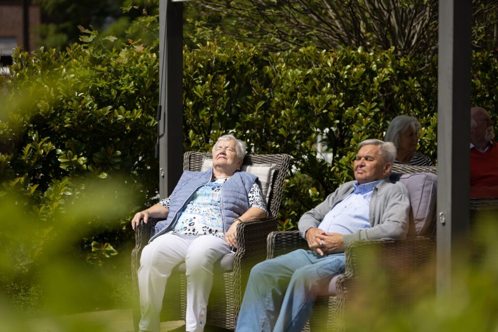 Ein Ehepaar sitzt auf der Dachterrasse und genießt - auf gemütlichen Sesseln - den strahlenden Sonnenschein.