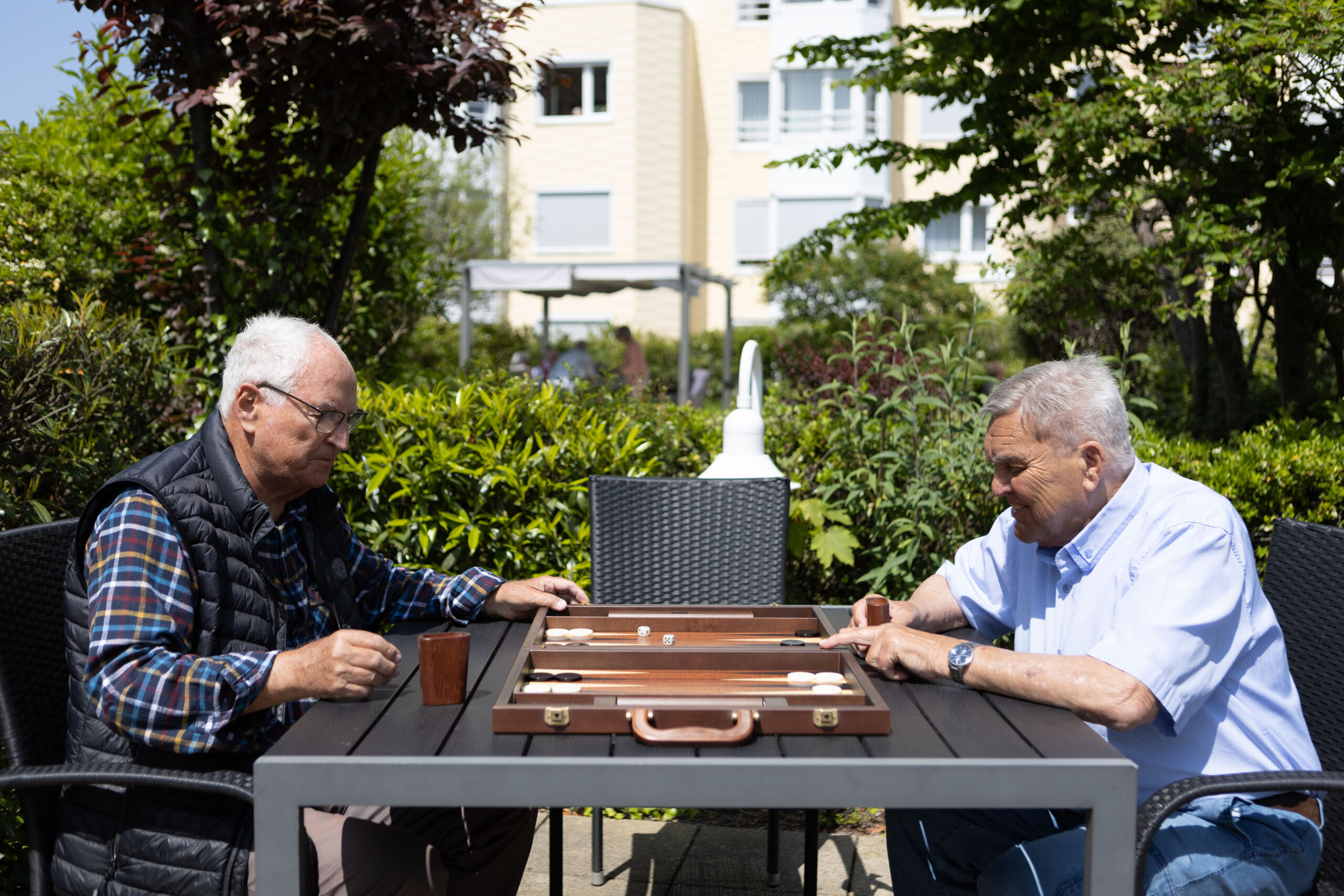 Zwei Männer spielen Backgammon auf der Dachterrasse.