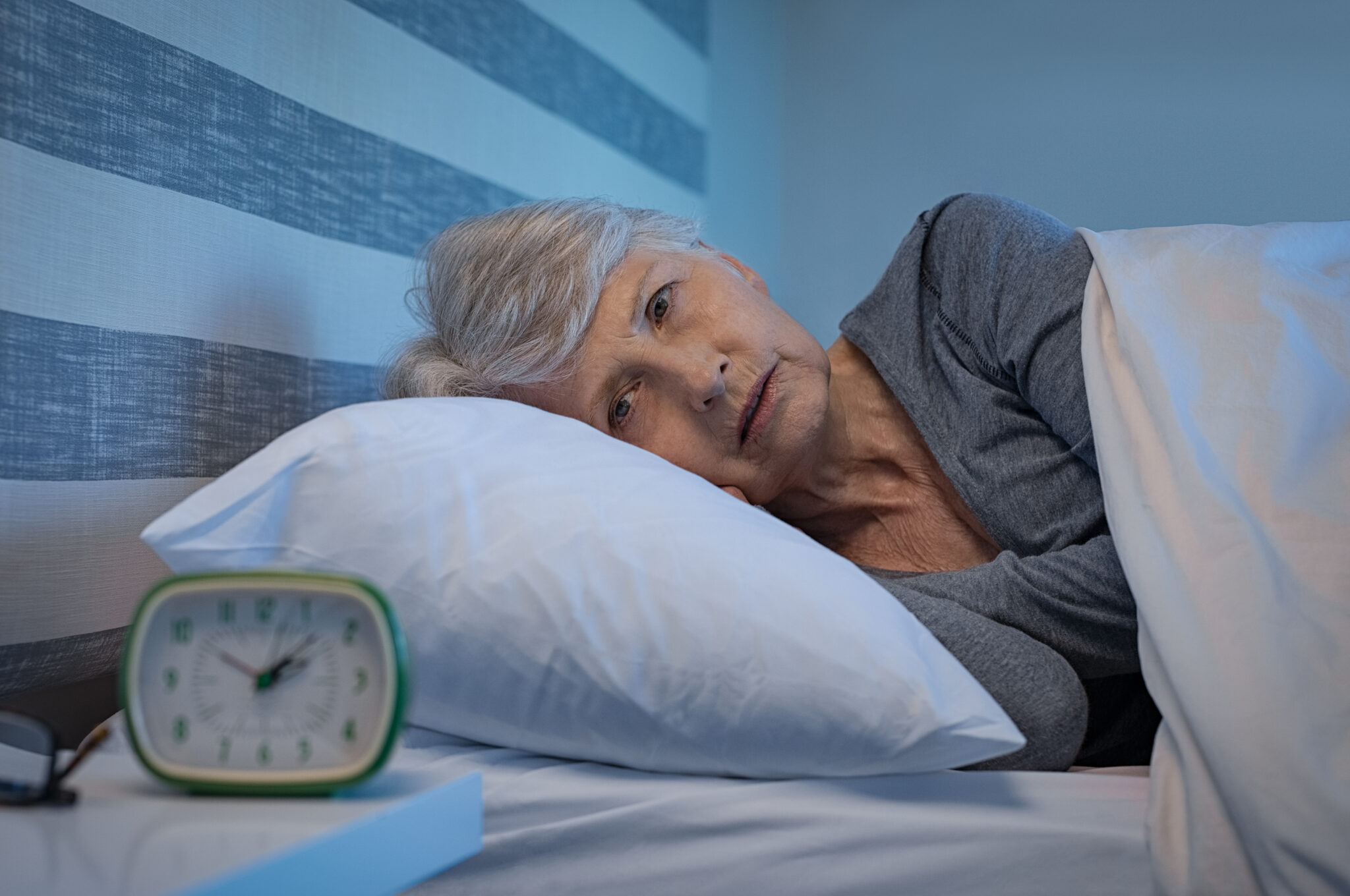 Eine Dame liegt im Bett und kann nicht schlafen.